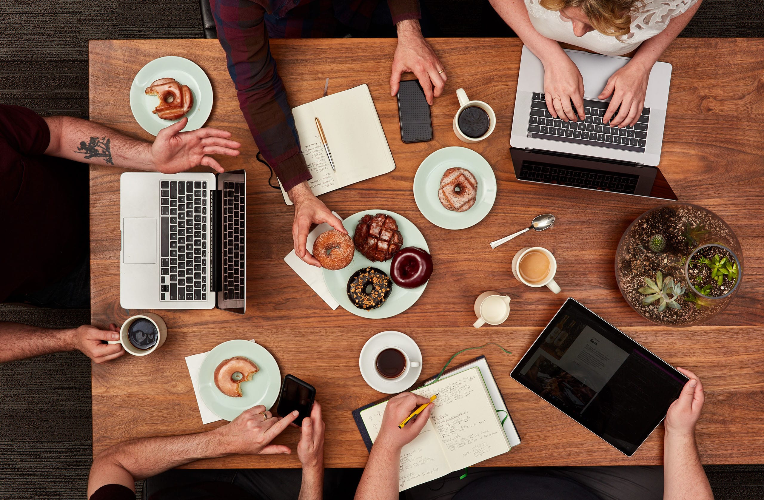 Grow Your Agency 1 agency community, people working at table with computers and donuts